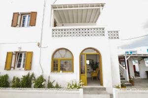 a white house with a yellow door at Asteri Hotel in Ornos