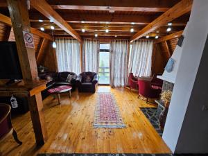 a living room with a couch and a tv at Casa Edenland Doftana in Trăisteni