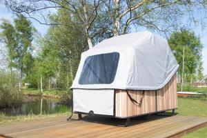 una tenda appoggiata su un molo vicino a un fiume di Schlafstrandkorb a Südbrookmerland