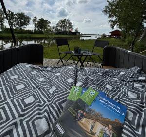 un letto con un libro sopra e un tavolo di Schlafstrandkorb a Südbrookmerland
