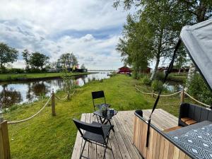una terrazza con sedie e vista sul fiume di Schlafstrandkorb a Südbrookmerland