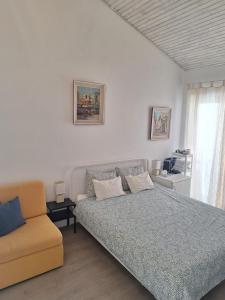 a bedroom with a bed and a couch and a window at Pension Oaza in Hvar