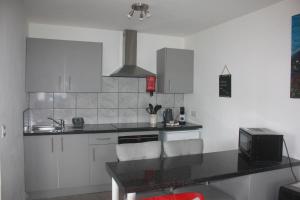 a kitchen with white cabinets and a black counter top at The Lodge in Newcastle Emlyn
