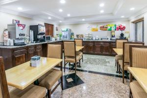 a restaurant with wooden tables and chairs and a counter at Quality Inn & Suites Atlanta Airport South in Atlanta +18 photos