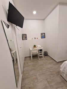 Zimmer mit einem Tisch und einem TV an der Wand in der Unterkunft Casa Sannì in Neapel