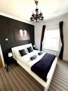 Un dormitorio con una cama grande y una lámpara de araña. en Bamboo Guesthouse, en Bournemouth