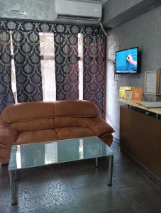 ein Wohnzimmer mit einem Sofa und einem TV in der Unterkunft КZO in Schymkent