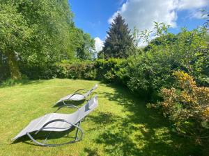 biała ławka siedząca w trawie w ogrodzie w obiekcie Newfoundland Cottage w mieście Whitechurch