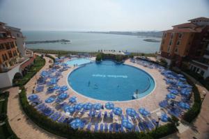 a large swimming pool with umbrellas and chairs at Marina in Aheloy