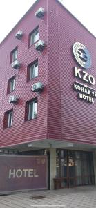 un edificio rojo con un hotel delante en КZO en Shymkent
