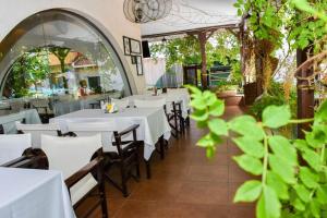 a dining room with white tables and chairs at Marina in Aheloy