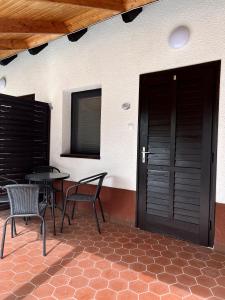 a patio with two chairs and a table and a door at Aniiza Apartman 2 in Örvényes