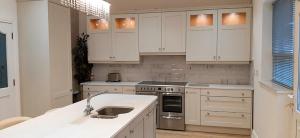 uma cozinha com armários brancos e um lavatório em No 2 Atlantic View Ballyshannon em Ballyshannon