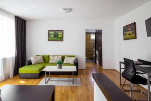 a living room with a green couch and a table at Apartament Family Rivulus 9 in Baia Mare