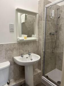 uma casa de banho com um lavatório e um chuveiro em The Strathearn Hotel em Fife