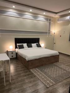 a bedroom with a large bed and a table at شاليهات توليب in Al Falt