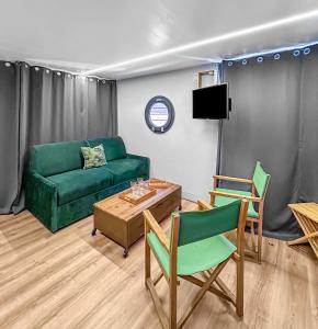 a living room with a couch and a table and chairs at Bord du Canal du Rhône à Sète sur "César" in Vauvert +21 photos