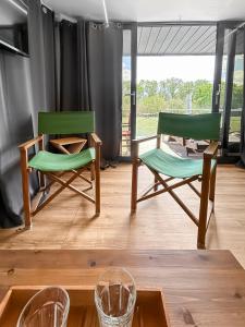 two green chairs and a table in a room at Bord du Canal du Rhône à Sète sur "César" in Vauvert