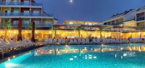 una piscina con sillas blancas y un edificio en Side Win Hotel & Spa - All Inclusive, en Side