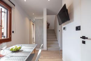 een eetkamer met een tafel en een televisie aan de muur bij Ebenus Residence in Rethimnon