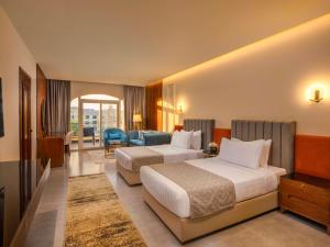 10月6日市にあるMövenpick Hotel Cairo - Media Cityのベッド2台とリビングルームが備わるホテルルームです。
