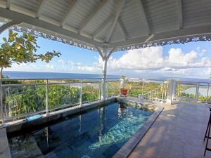 a swimming pool with a view of the ocean at Aux Colibris Amoureux : loft de standing avec vue mer in Grand-Bourg