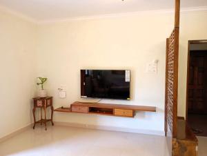 a living room with a flat screen tv on a wall at Cielo in Palolem