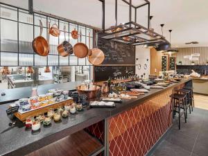 a kitchen with a long counter with food on it at Mercure Katowice Centrum in Katowice