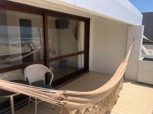 a hammock on the balcony of a house at Pousada Beira Mar - Suítes Frente ao mar in Torres