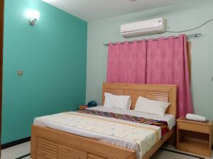 穆札法拉巴德的住宿－Mount Heaven Lodges Muzaffarabad，一间卧室配有一张带粉红色窗帘的床