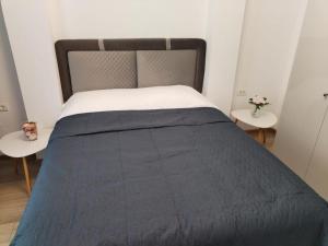 1 cama con edredón azul y 2 mesas en Hotel Emma, en Bucarest