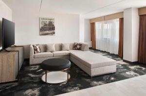 DoubleTree by Hilton Poughkeepsie في باوكيبسي: غرفة معيشة مع أريكة وطاولة