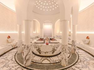a large white room with a table in the middle at Rixos Premium Qetaifan Island North in Doha
