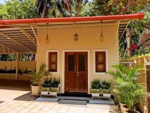 a house with a wooden door and plants at Cielo in Palolem