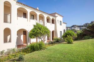duży biały dom z zielonym trawnikiem w obiekcie Mangia's Santa Teresa Sardinia, Curio Collection by Hilton w mieście Santa Teresa Gallura