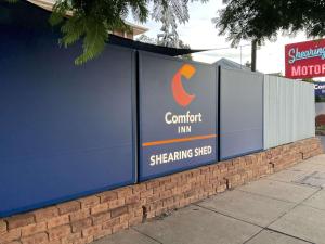 a sign for a comfort inn on a wall at Comfort Inn Shearing Shed in Dubbo