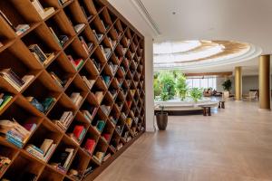 a large wall of bookshelves in a living room at Isla Brown Chania Resort, Curio Collection by Hilton in Stavros