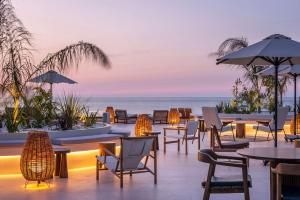 un restaurante en la playa con mesas y sillas en Isla Brown Chania Resort, Curio Collection by Hilton en Stavros