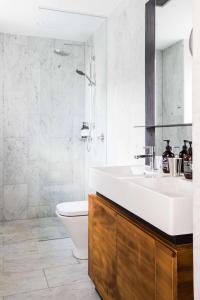 a bathroom with a sink and a toilet and a shower at The Old Clare Hotel, Independent Collection by EVT in Sydney