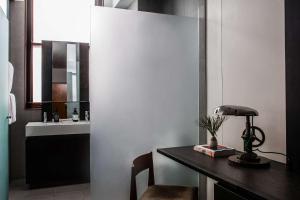 a bathroom with a desk with a lamp and a sink at The Old Clare Hotel, Independent Collection by EVT in Sydney