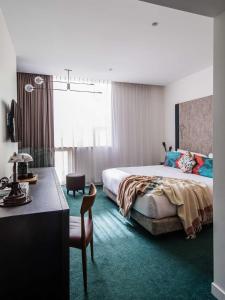 a bedroom with a bed and a desk with a chair at The Old Clare Hotel, Independent Collection by EVT in Sydney