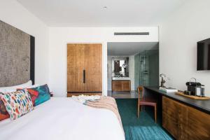 a bedroom with a bed and a desk with a television at The Old Clare Hotel, Independent Collection by EVT in Sydney