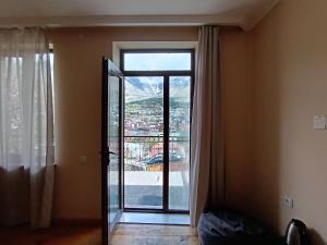 a room with a large glass door with a view at Belas guesthouse in Stepantsminda