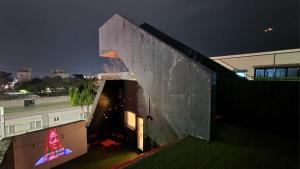 a building with a lit up sign on the side of it at Mir Guesthouse in Jeju
