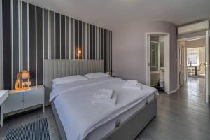 a bedroom with a large white bed with towels on it at Silver Apartment With Hot Tub And Balcony - Happy Rentals in Zagreb