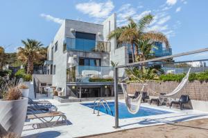 una imagen de una casa con columpios y piscina en Clauhomes Villa Al Mar Deluxe, en Tarragona