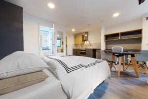 a bedroom with a white bed and a kitchen at Canvas Wembley in London in London