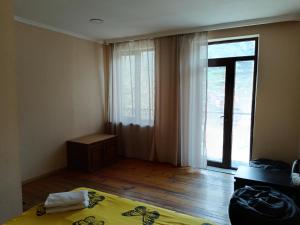 a bedroom with a bed and a large window at Belas guesthouse in Stepantsminda