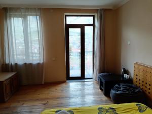 a bedroom with a bed and a door with a window at Belas guesthouse in Stepantsminda