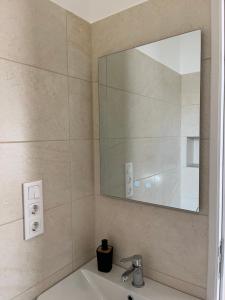 a bathroom with a sink and a mirror at Luca Apartman in Gyenesdiás